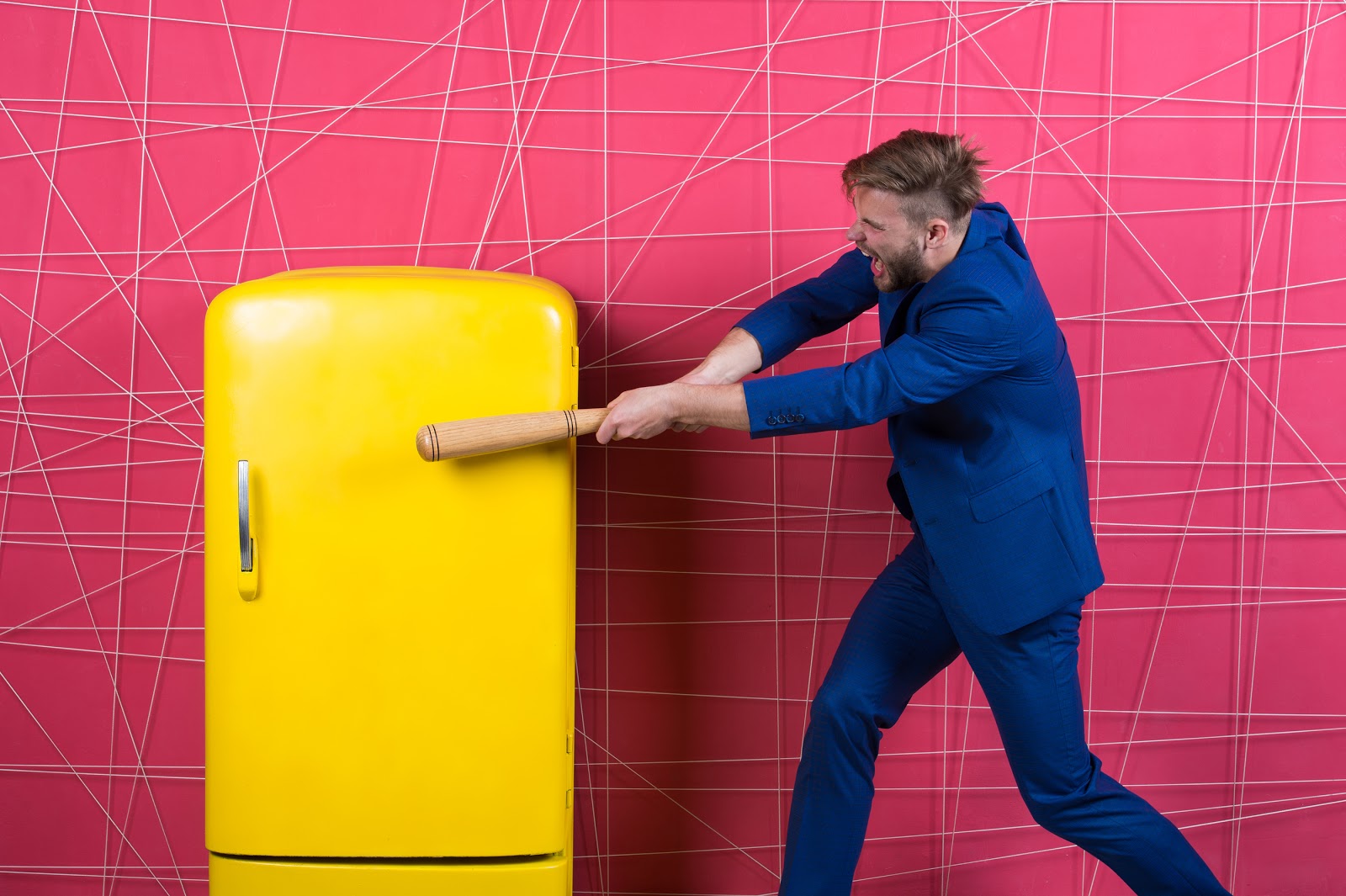 yellow-refrigerator-with-man-hitting-it-with-a-baseball-bat