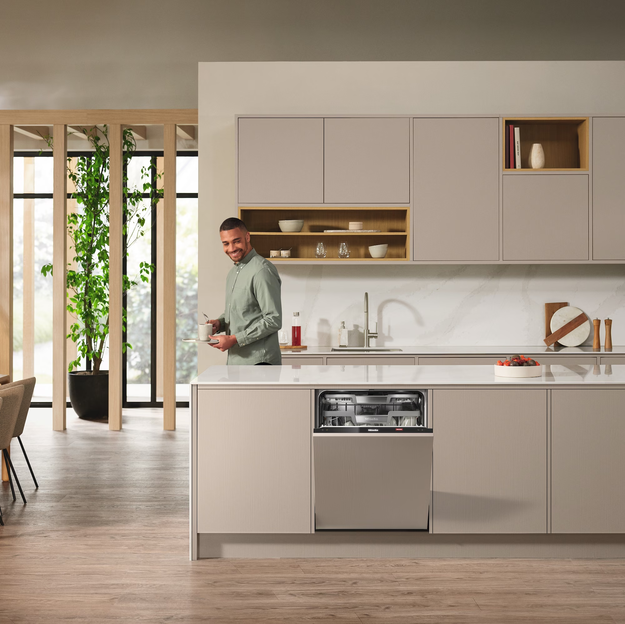 Man in kitchen with dishwasher.