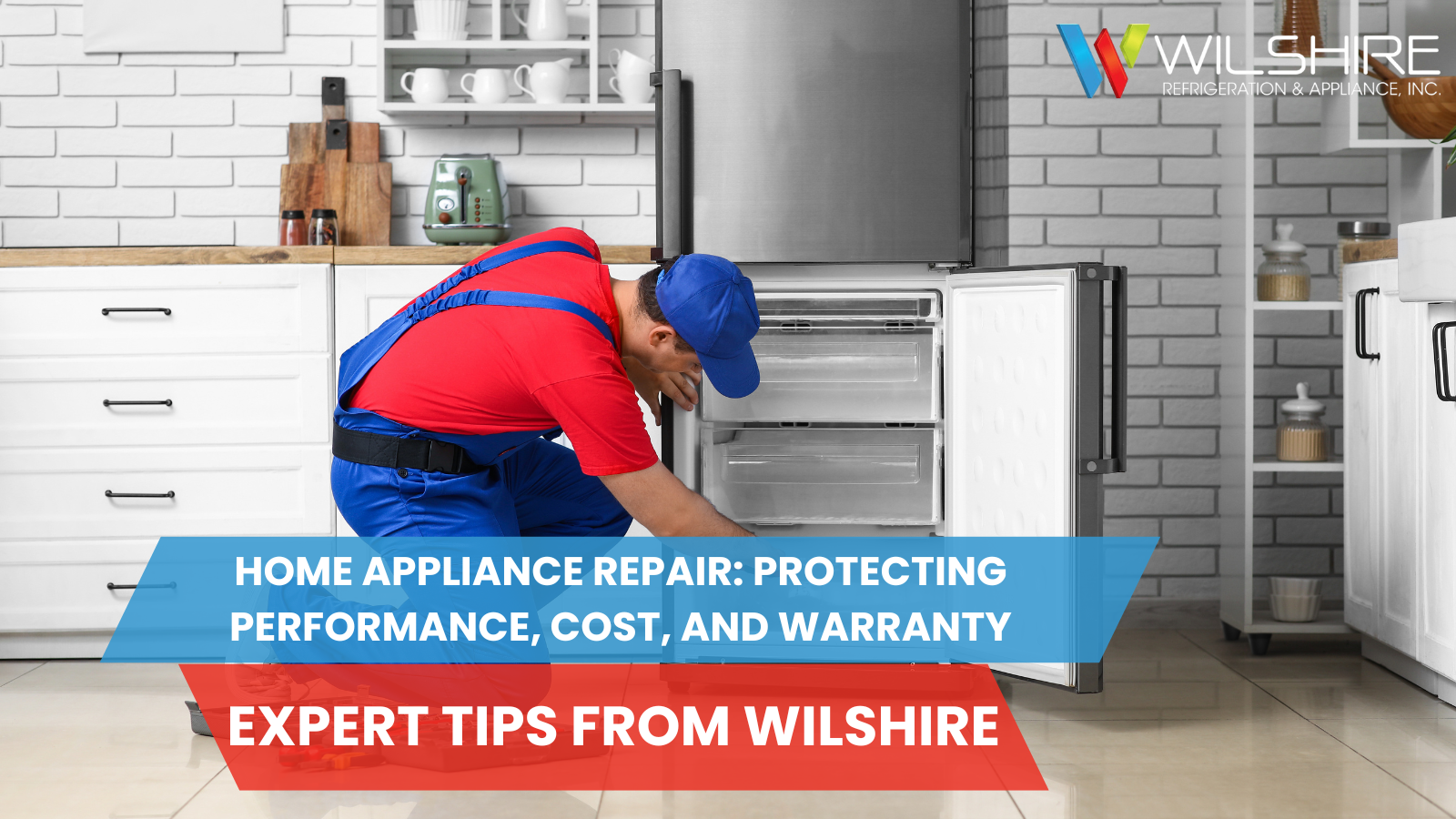 A person in a red shirt and blue overalls kneels and fixes the inside of an open refrigerator in a bright kitchen.