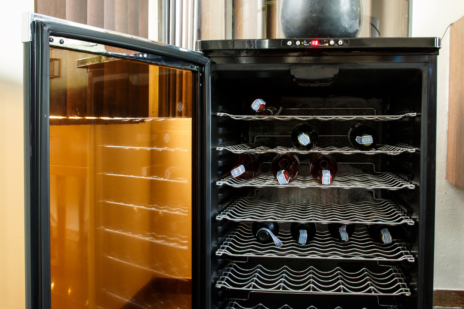 Close-up of a wine cooler with rattling shelves and noisy internal fan indicating loud buzzing, clicking, and vibrations that require wine cooler repair.