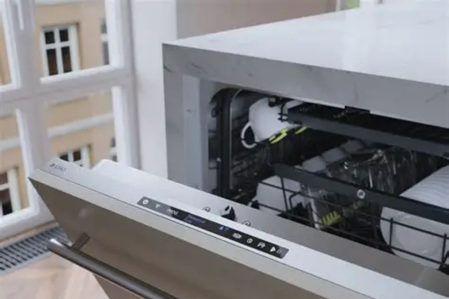 Built-in dishwasher partially open with dishes inside.