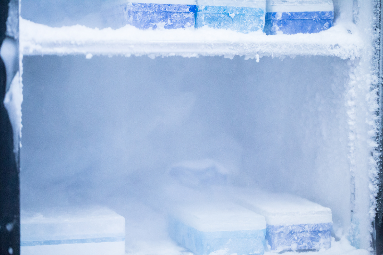 Freezer walls covered in thick, uneven frost, illustrating common causes of frost buildup such as warm air leaks or moisture entering the compartment.