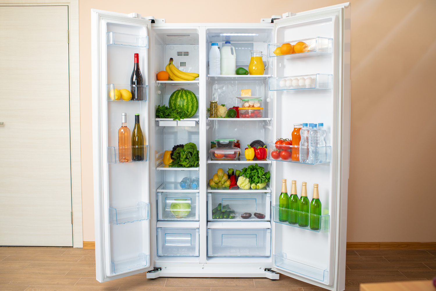 Open double-door refrigerator filled with fresh produce, milk, and beverages, emphasizing the need to maintain the right refrigeration temperature for food safety.