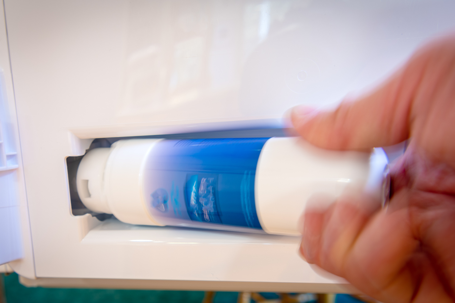 Refrigerator water filter being removed to show how fridge water is filtered