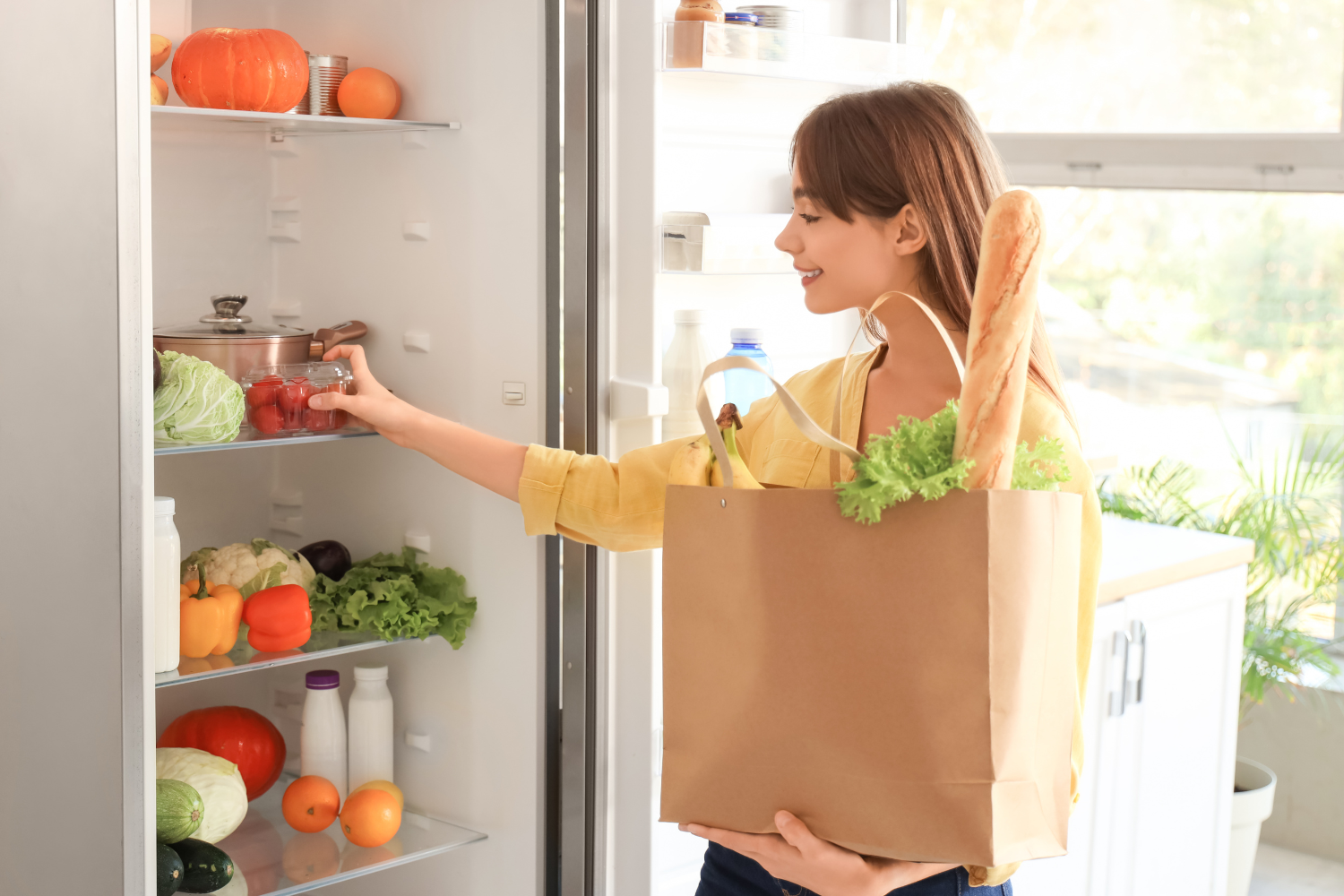  Alt text: "Person organizing fresh cherry tomatoes into a refrigerator, emphasizing the importance of maintaining the right refrigeration temperature for food safety.