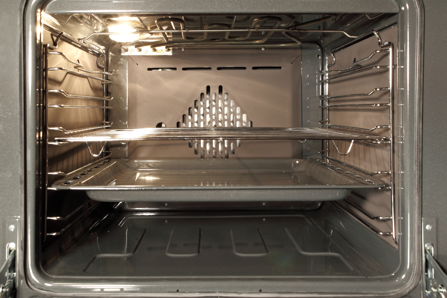 Empty oven interior with racks and heating area for Miele oven not heating repair troubleshooting.