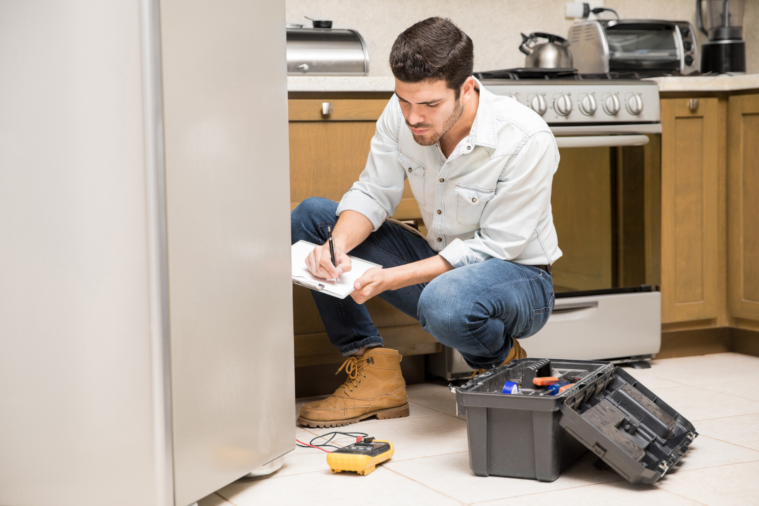 Appliance technician inspecting refrigerator for Sub Zero refrigerator repair service