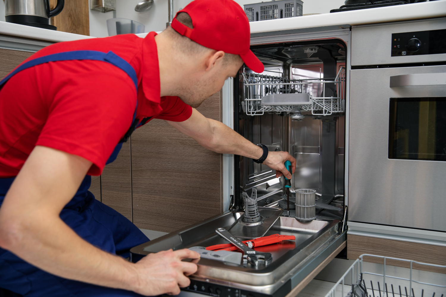 Technician repairing a built-in dishwasher
