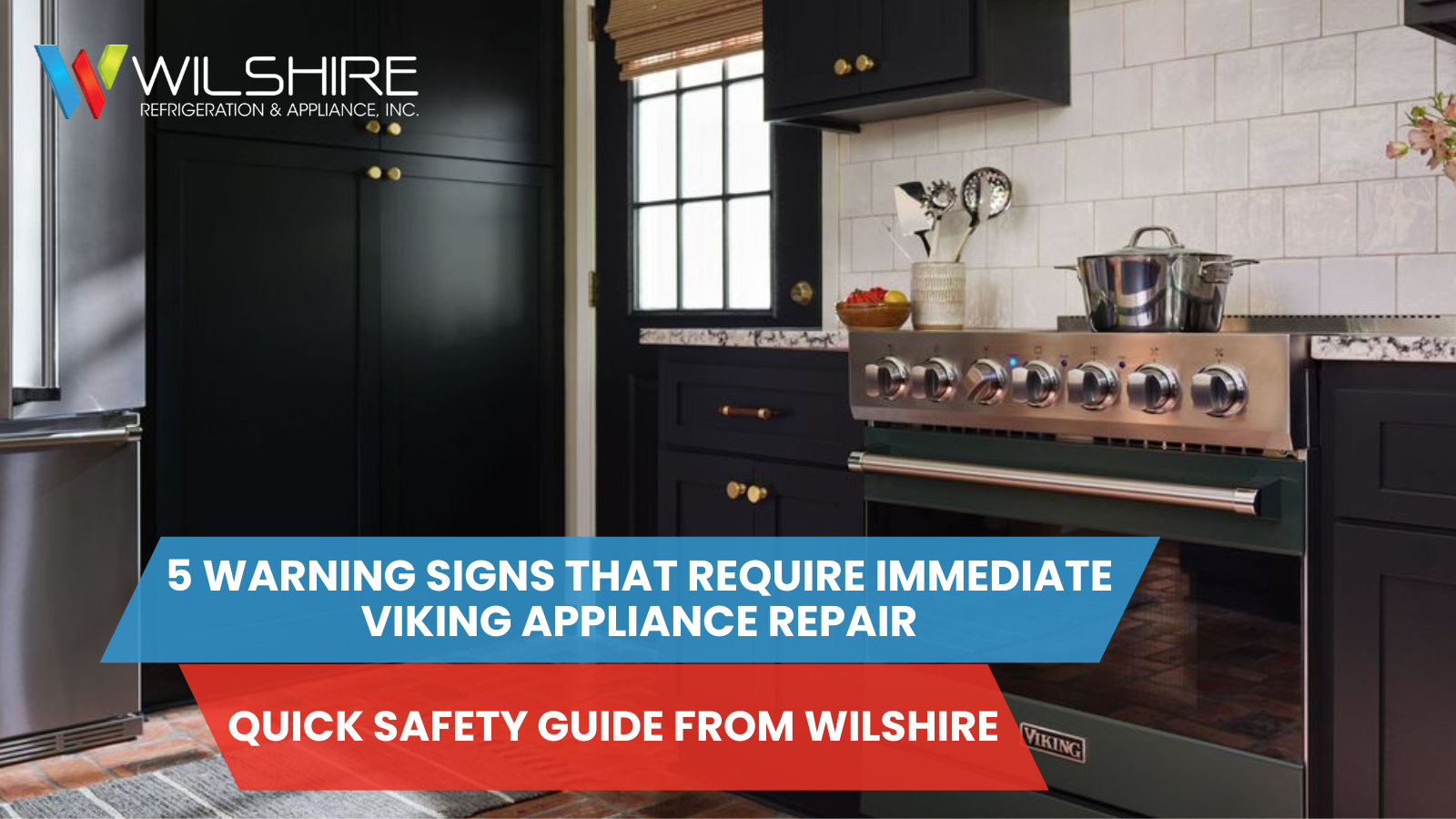 A dark kitchen with black cabinets, a stainless steel Viking range with a pot on top, and a brick floor.
