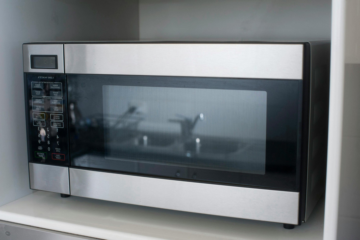 Built-in stainless steel microwave installed in custom kitchen cabinetry.