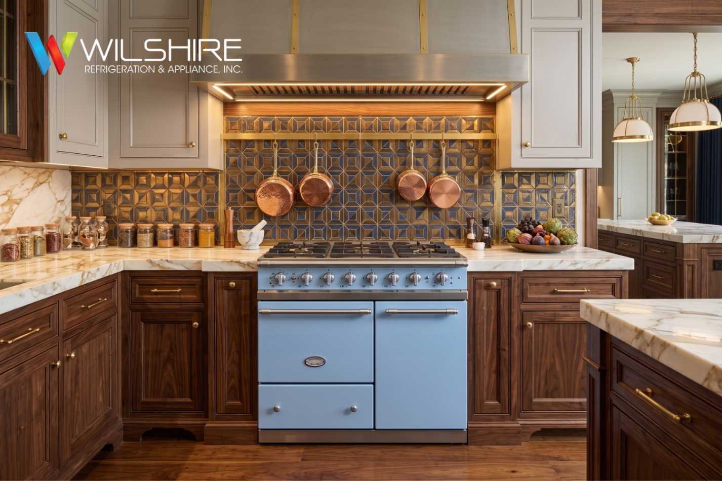 Spacious kitchen with dark wood cabinetry, a blue center Lacanche stove, ornate copper pots and tiles on the backsplash, warm under-cabinet lighting, and hanging pendant lights over the countertop.