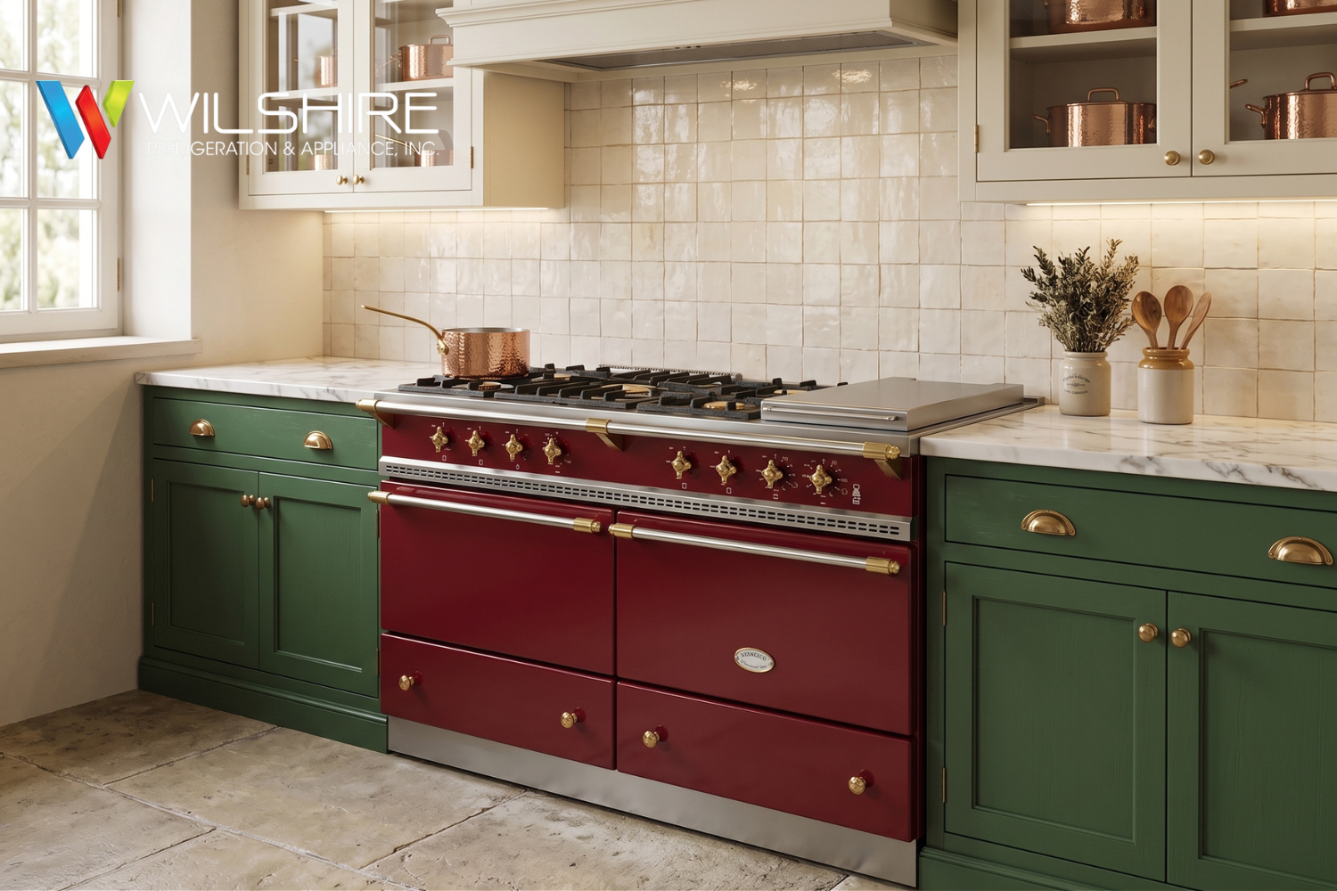 Green and deep-red vintage-style kitchen with a Lacanche gas range in the center, brass knobs and trim, white tile backsplash, open shelves, and a window on the left.