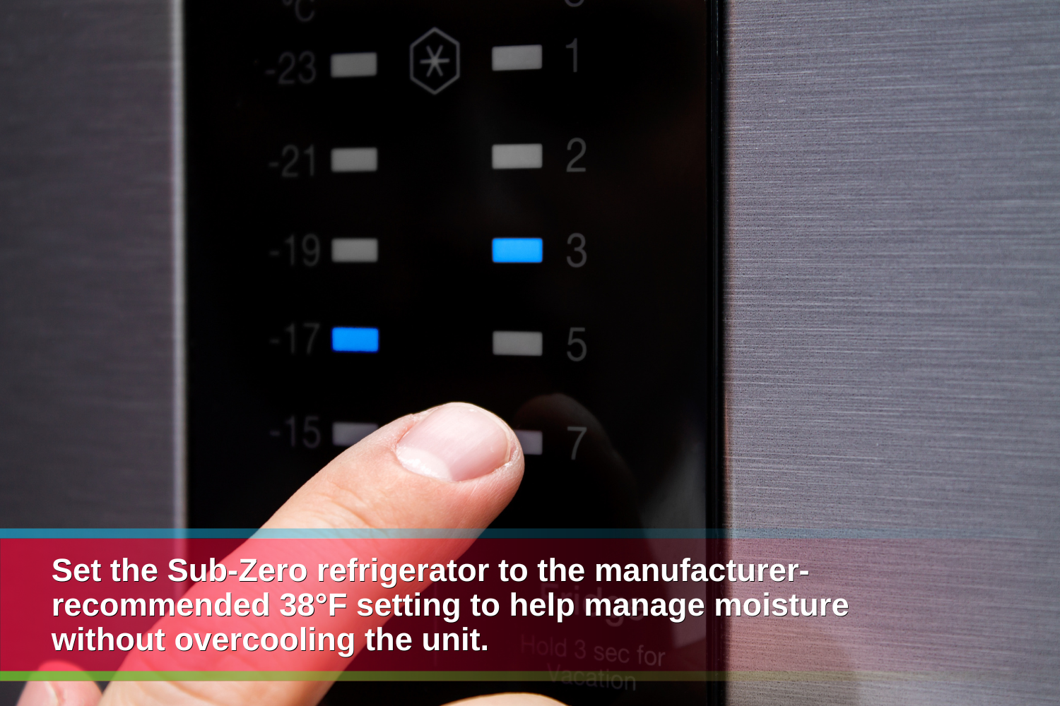 Finger adjusting the electronic temperature controls on a stainless steel Sub-Zero refrigerator to maintain the recommended 38°F setting.
