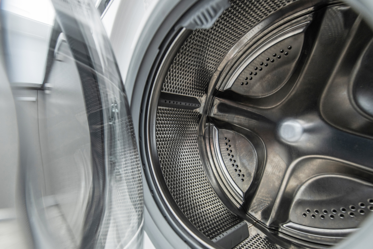 Close-up view of the inside of a washing machine drum with the door open.