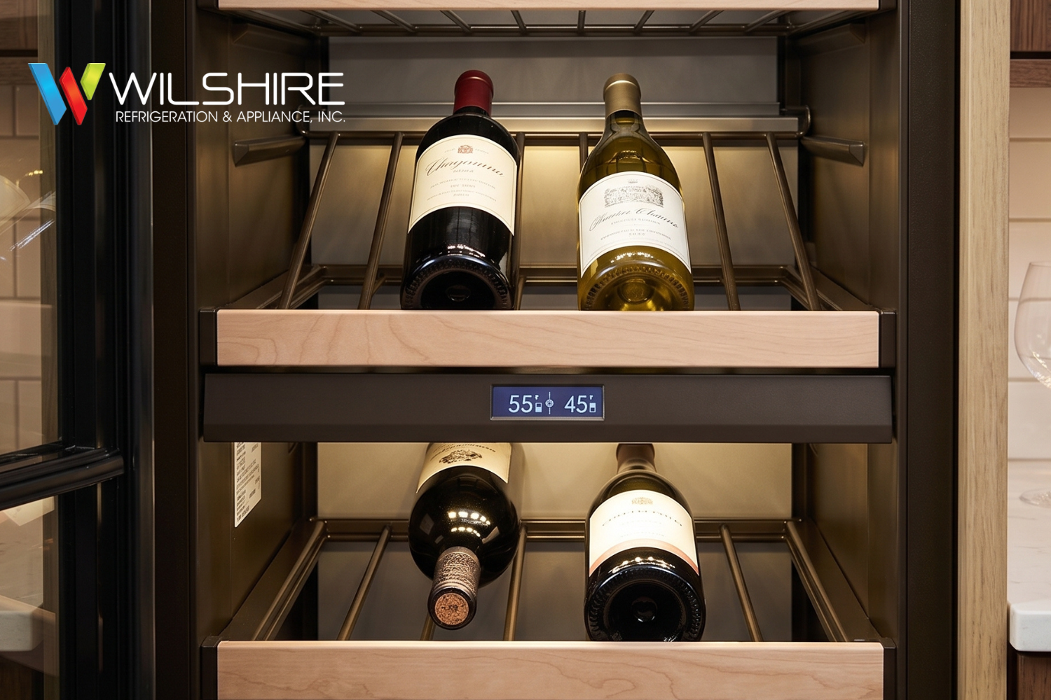 Built-in wine storage with four bottles arranged on wooden shelves inside a dark metal cabinet, with a small digital temperature display centered on the unit.