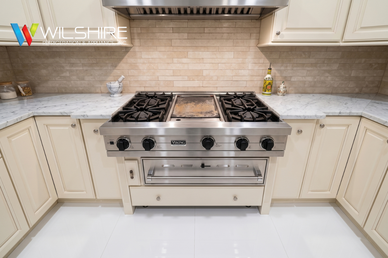 Viking Professional range with a central griddle and cast-iron burners in a bright luxury kitchen.