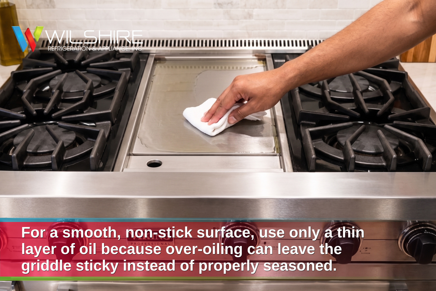 A hand is shown applying a thin layer of oil on the stainless steel griddle of a Viking Professional range cooktop.