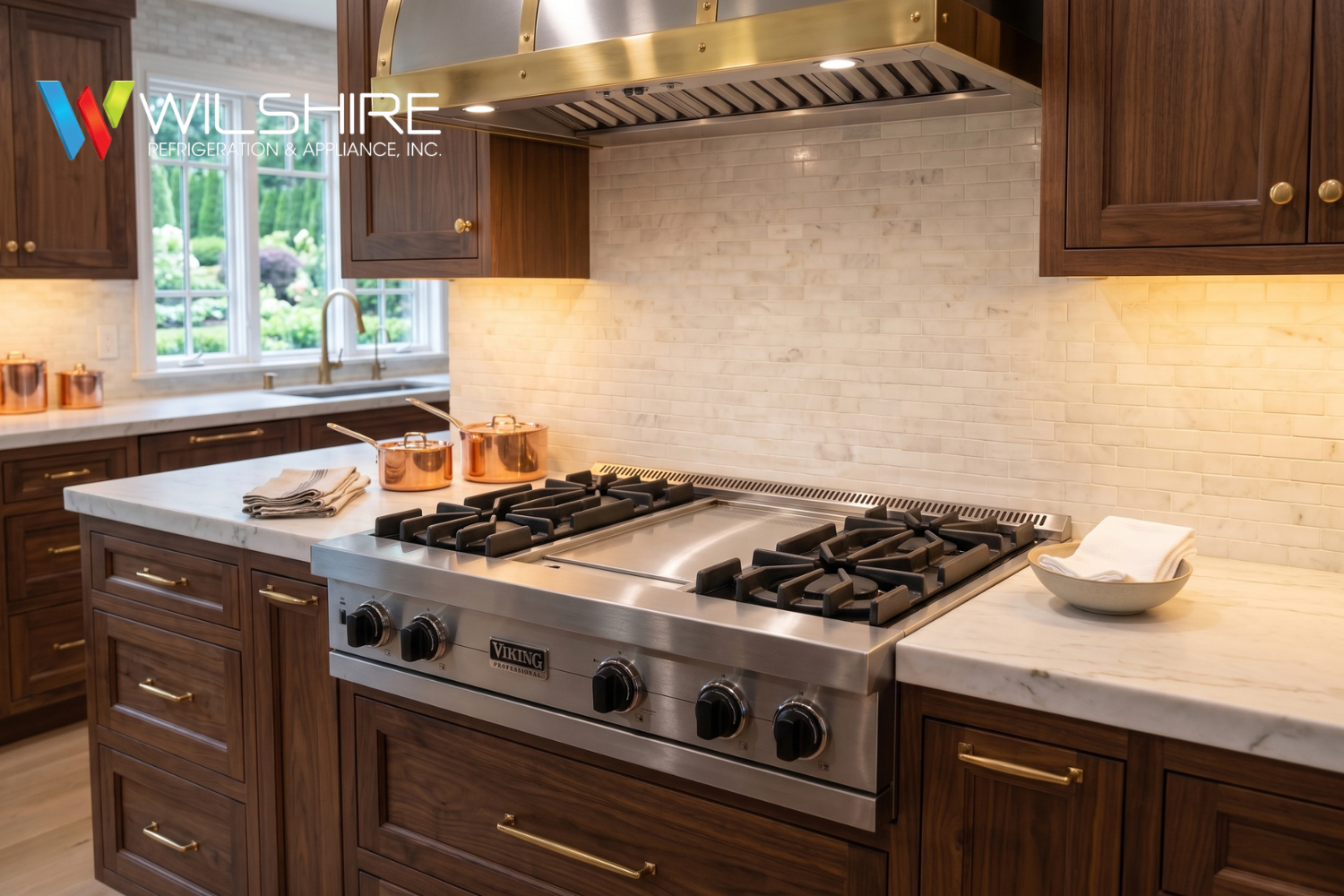 Viking Professional stainless steel range with a central griddle, cast-iron burners, and matching hood in a luxury kitchen.